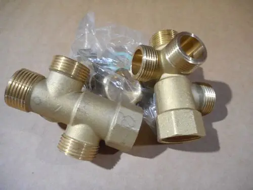 Anschlusskreuz aus Messing mit mehreren Gewindeanschlüssen, verpackt in einer durchsichtigen Plastiktüte. Hersteller ist Remeha.